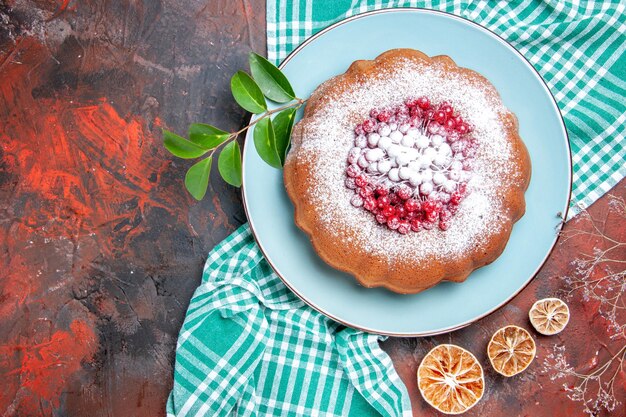 Side close-up view a cake a cake with berries and sugar leaves on the tablecloth lemon