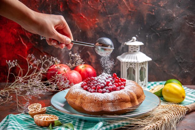 측면 클로즈업 보기 케이크 감귤류 과일 손에 딸기 사과 숟가락이 있는 케이크