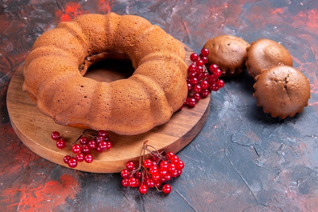 Foto gratuita vista ravvicinata laterale torta cupcakes tre cupcakes una torta con ribes rosso sul tagliere