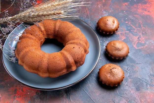 Vista ravvicinata laterale di un piatto di torta di torta di spighe di grano cupcakes e rami di albero