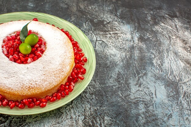 Side close-up view cake with pomegranate an appetizing cake with citrus fruits and pomegranate