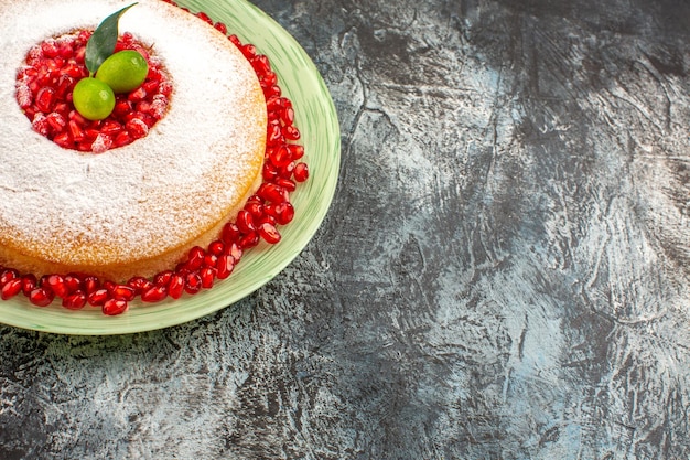 Side close-up view cake with pomegranate an appetizing cake with limes and seeds of pomegranate