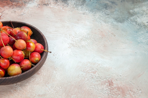 Side close-up view cherries the appetizing cherries in the wooden bowl on the table