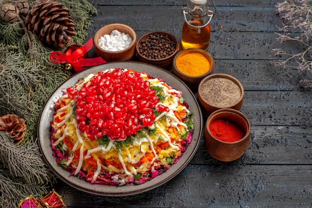 Free photo side close-up view christmas food christmas food next to the tree branches with cones spices and oil