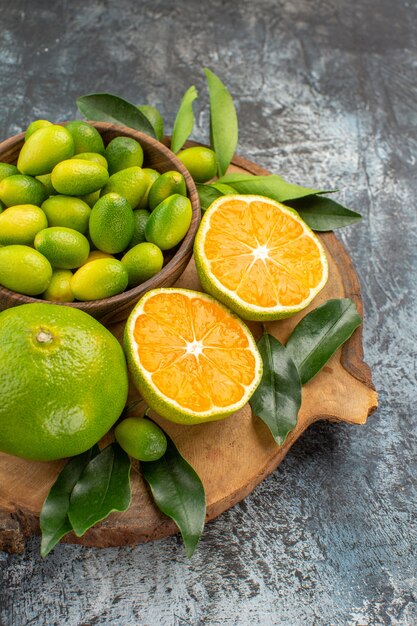 Side close-up view citrus fruits citrus fruits with leaves on the wooden board