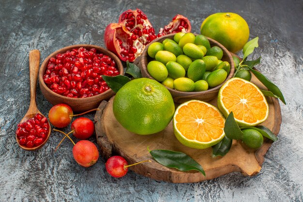 Side close-up view citrus fruits pomegranate seeds in bowl citrus fruits on the board