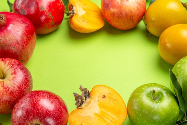 측면 클로즈업 보기 다채로운 과일 석류 사과 감 및 테이블에 나뭇잎