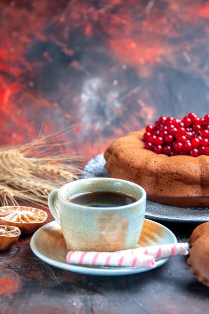Side close-up view a cup of tea an appetizing cake a cup of black tea sweets wheat ears
