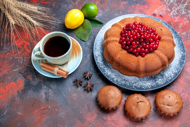 Вид сбоку крупным планом чашка чая аппетитный торт кексы цитрусовые фрукты чашка чая звездчатый анис