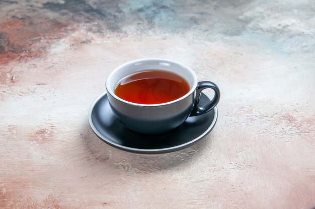 Side close-up view a cup of tea black cup of tea on the table