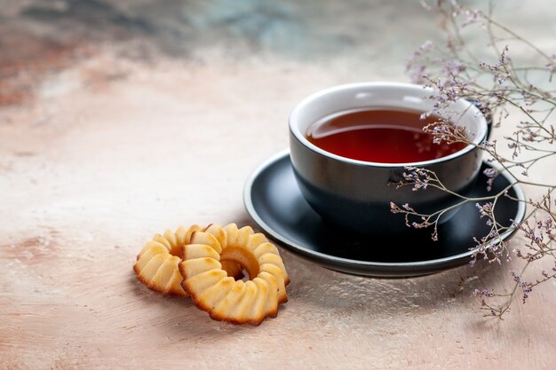 Side close-up view a cup of tea a cup of tea cookies tree branches