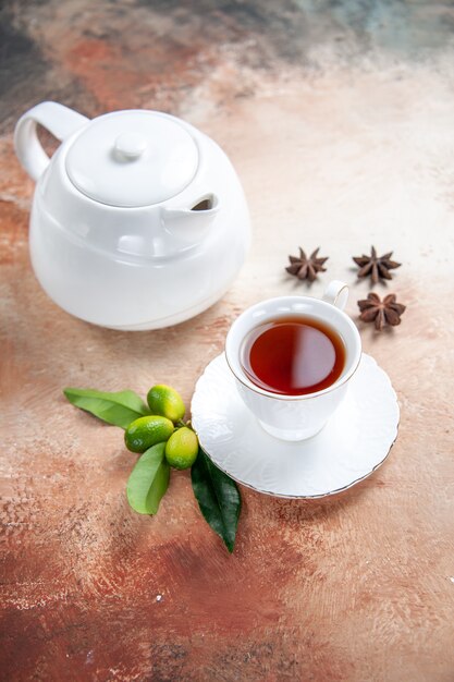 Вид сбоку крупным планом чашка чая белый чайник чашка чая цитрусовые бадьян