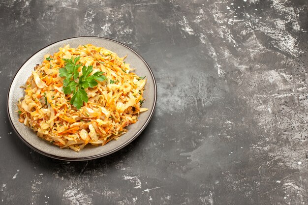 Side close-up view dish the appetizing dish of carrots cabbage and herbs on the white plate