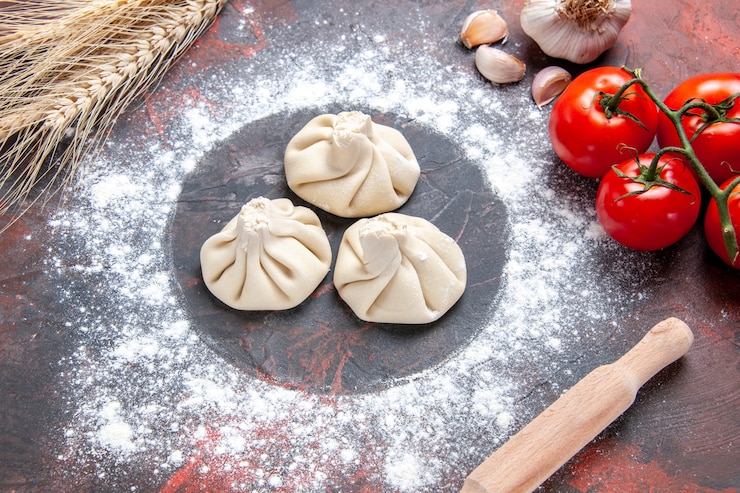 Free Photo side close-up view flour khinkali flour tomatoes with pedicels garlic rolling pin