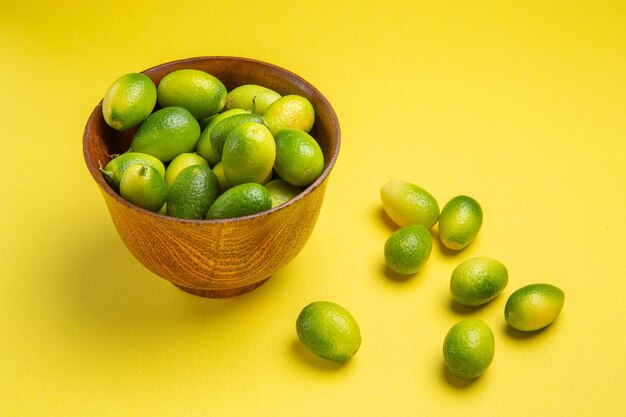 側面のクローズアップビューは、黄色い表面のボウルの横にある食欲をそそる緑色の果物を実らせます
