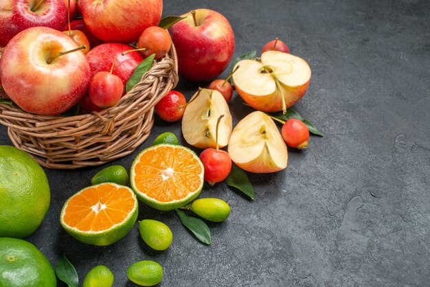Вид сбоку крупным планом фрукты, фрукты, ягоды в корзине рядом с разными фруктами