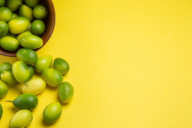 Side close-up view green fruits brown bowl of the appetizing green fruits on the table