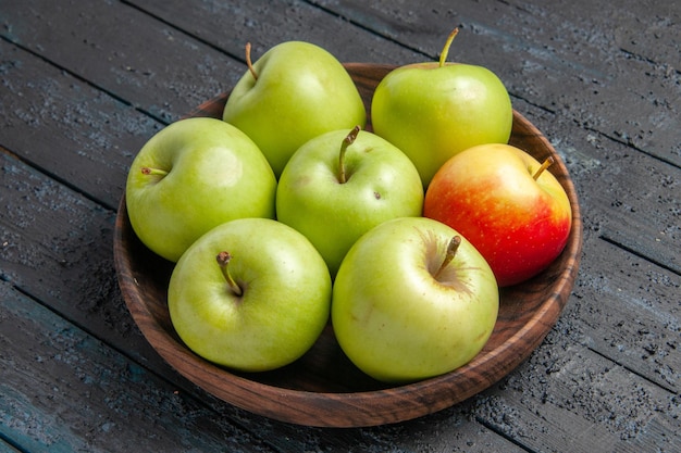 Side close-up view green-yellow-reddish apples a bowl of appetizing green yellow reddish apples on the grey table