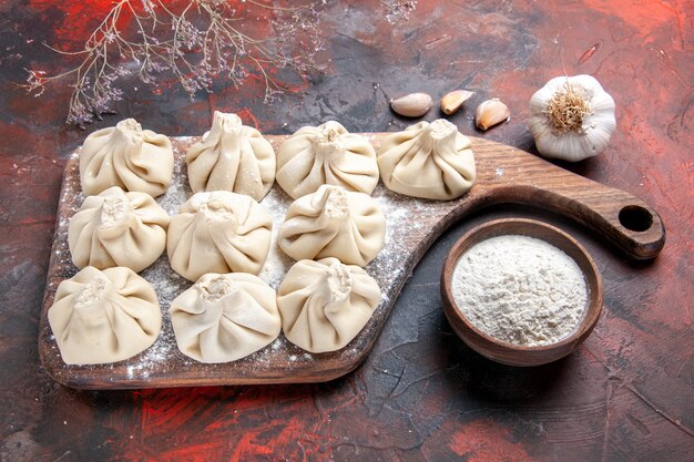 Side close-up view khinkali the appetizing khinkali on the board garlic bowl of flour