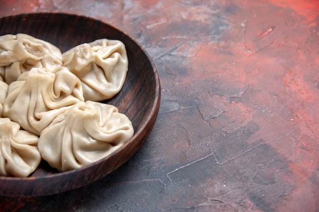 Free photo side close-up view khinkali the appetizing khinkali on the red-blue table