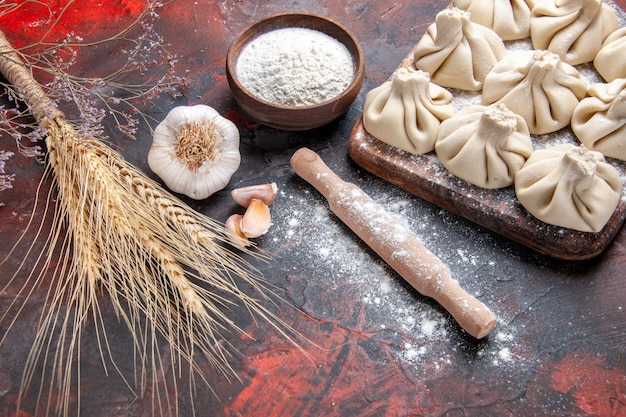 Free photo side close-up view khinkali khinkali on the board flour rolling pin garlic wheat ears