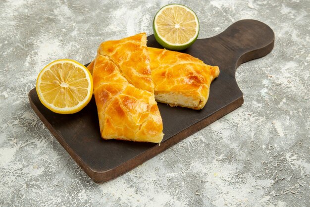 Side close-up view lemon and lime lime lemon and appetizing pies on the cutting board in the center of the table