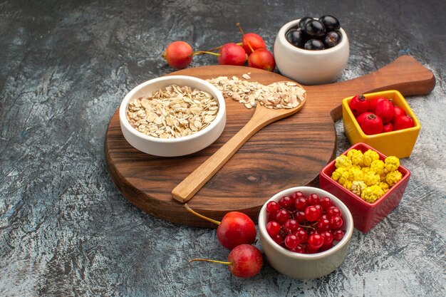 Side close-up view oatmeal oatmeal spoon on the board berries yellow candies