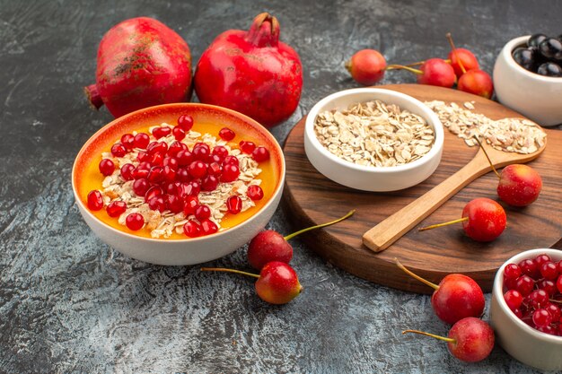 Side close-up view oatmeal oatmeal spoon on the cutting board the appetizing berries pomegranate