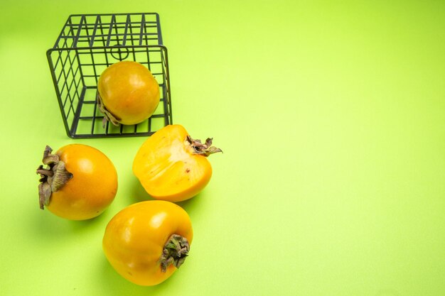 Side close-up view persimmons basket with persimon next to the three appetizing persimmons