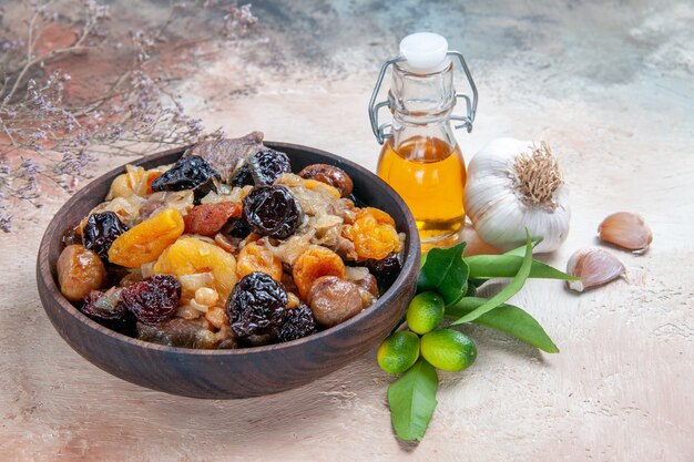 Side close-up view pilaf brown bowl of pilaf garlic oil citrus fruits