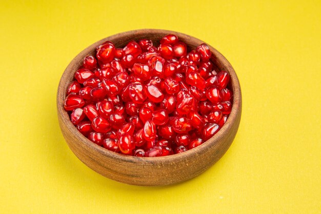 Side close-up view pomegranate the appetizing seeds of pomegranate in the brown bowl
