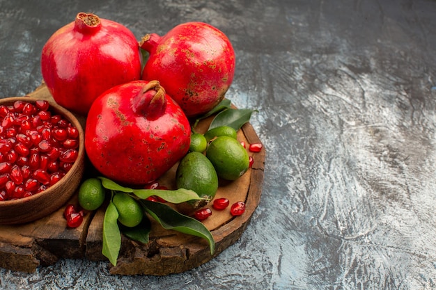 Side close-up view pomegranates ripe pomegranate with leaves on the wooden cutting board