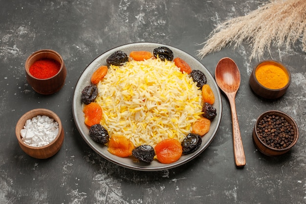 Side close-up view rice colorful spices spoon plate of rice with dried fruits