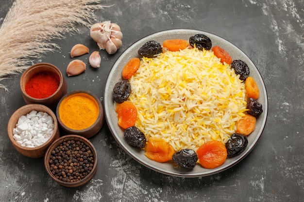 Бесплатное фото Боковой вид крупным планом рисовый рис с сушеными фруктами, чесноком и специями