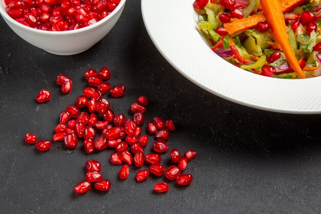 Side close-up view salad seeds of pomegranate plate of vegetable salad