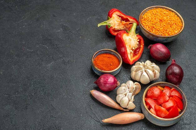 side close-up view vegetables bowl of lentil bell peppers tomatoes spices on the black table