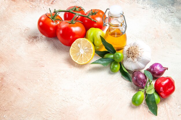 Side close-up view vegetables onion garlic lemon tomatoes with pedicels oil bell pepper