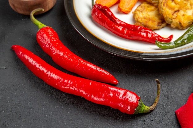 Free photo side close-up view vegetables plate of roasted vegetables red hot peppers