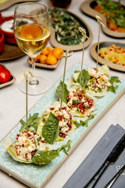 Side dish with peppers grated cheese and greens served with glass of wine