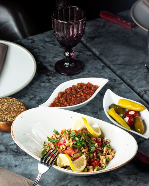 Side dishes with tomato salad pickles plate and spicy aubergine salad