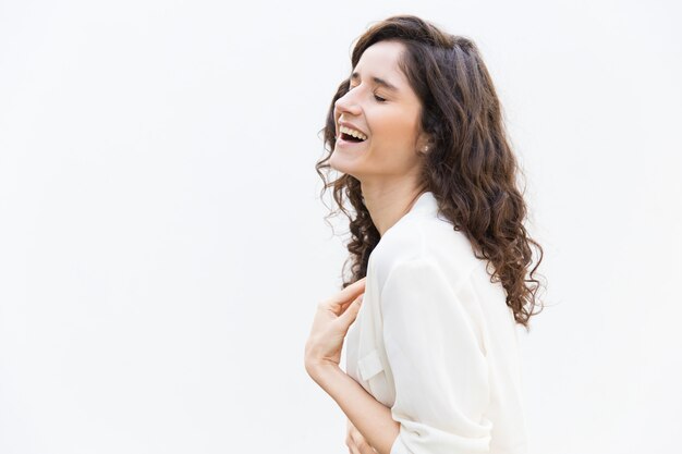 Side of happy cheerful woman laughing with closed eyes