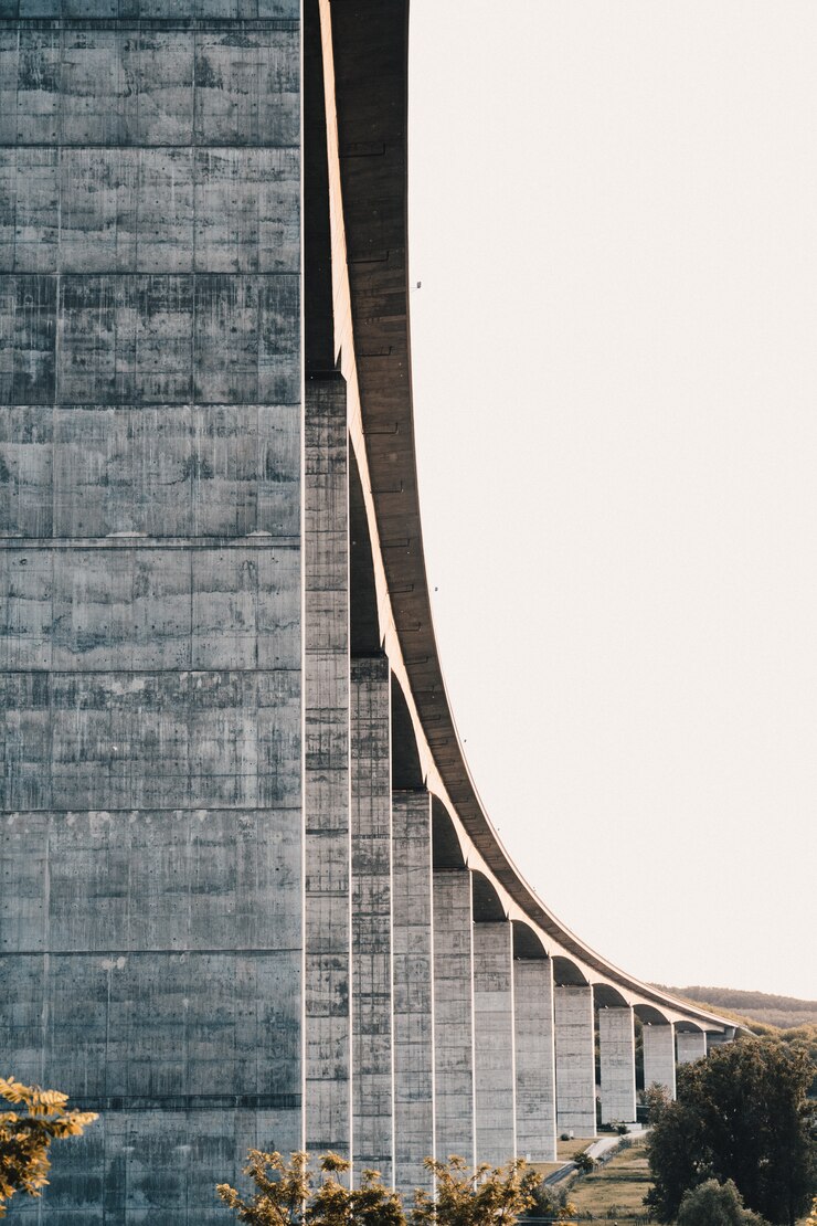 Free Photo side of a high stone highway bridge with clear white sky in the background