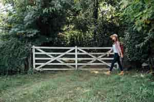 Бесплатное фото Боковой снимок женщины, проходящей мимо ворот