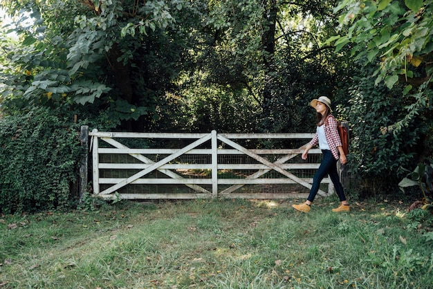 Free photo side shot of woman passing by a gate