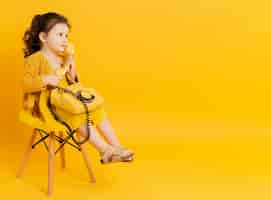 Free photo side view of adorable child posing with telephone