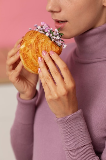 Side view adult holding croissant