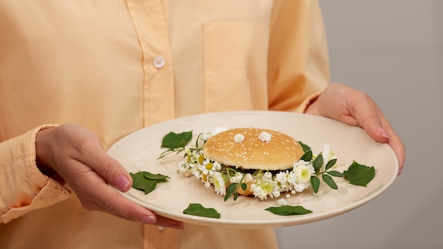 Side view adult holding plate with burger