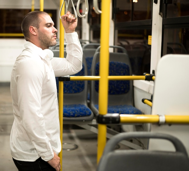 Foto gratuita maschio adulto di vista laterale che guida il bus