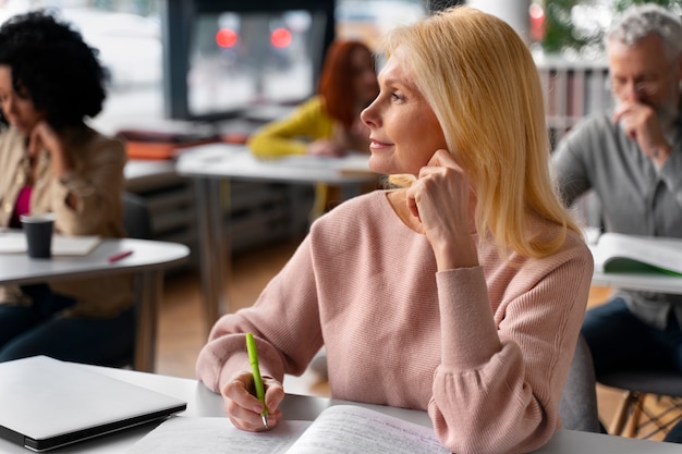 Foto gratuita adulti vista laterale che studiano insieme