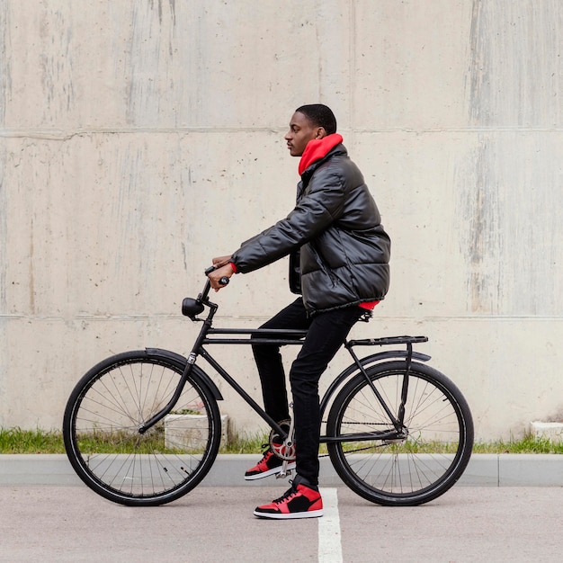 측면보기 아프리카 계 미국 흑인 남자와 그의 자전거